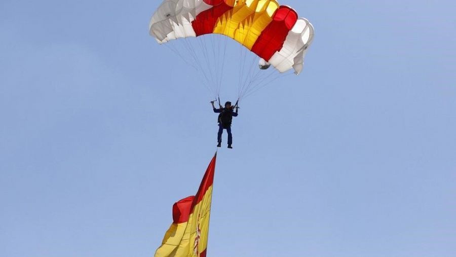La cabo Carmen Gómez Hurtado salta en paracaídas con la bandera de España en el Día de las Fuerzas Armadas 2023.