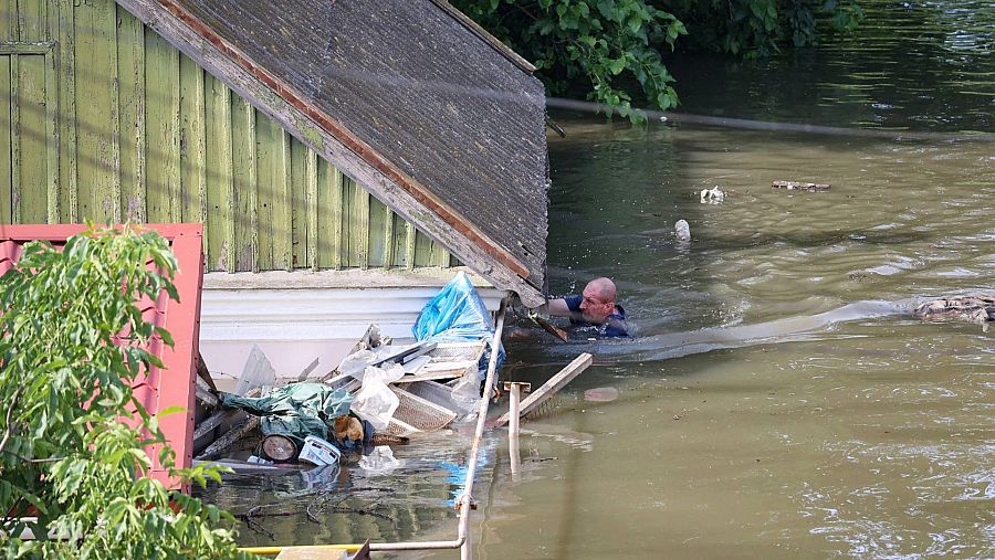 Un vecino nada junto a una casa en una zona inundada de Jersón. (Foto: Olexander Kornyakov / AFP)