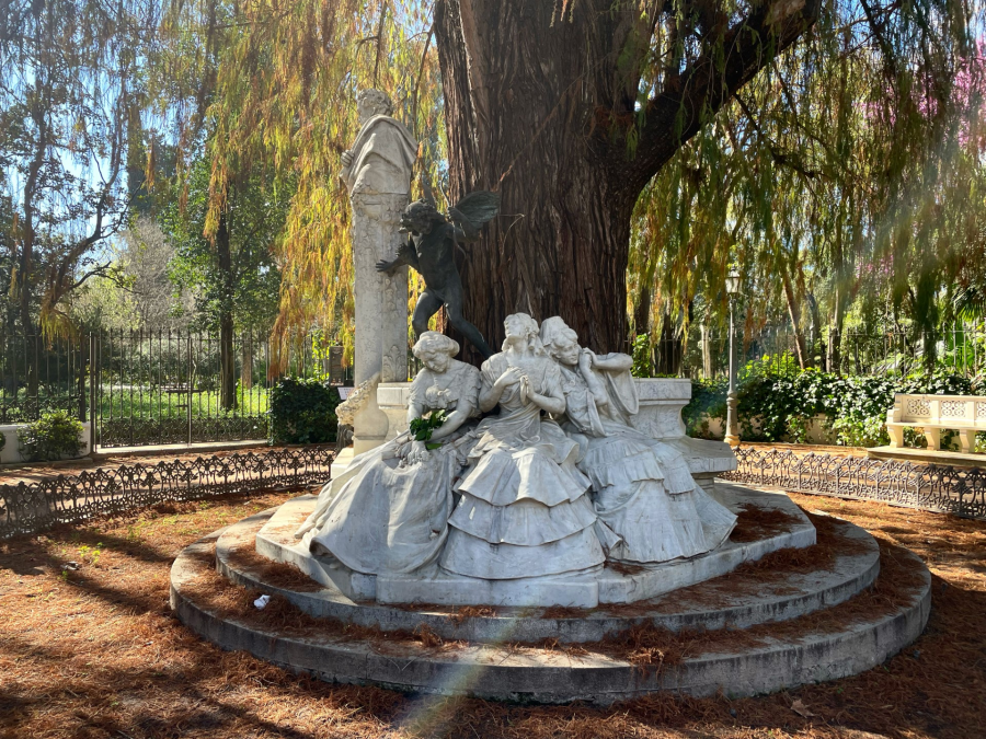 Junto a un ciprés de los pantanos, tres figuras: el amor que llega, el presente y el perdido, en la glorieta de Bécquer, obra de Lorenzo Coullaut Valera realizada en Barcelona