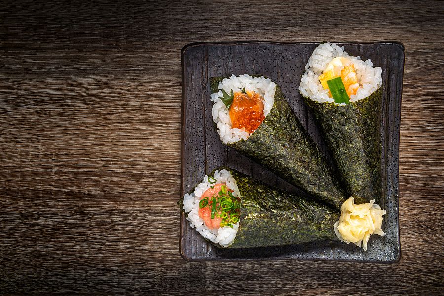 Japanese style of temaki with shrimp, caviar, fish on black plate, Asian food, traditional Japanese food, copy space