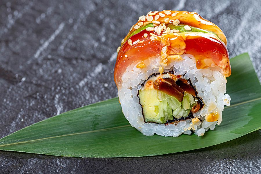 Close - up of sushi rainbow dragon on a green leaf on a black background,Romania