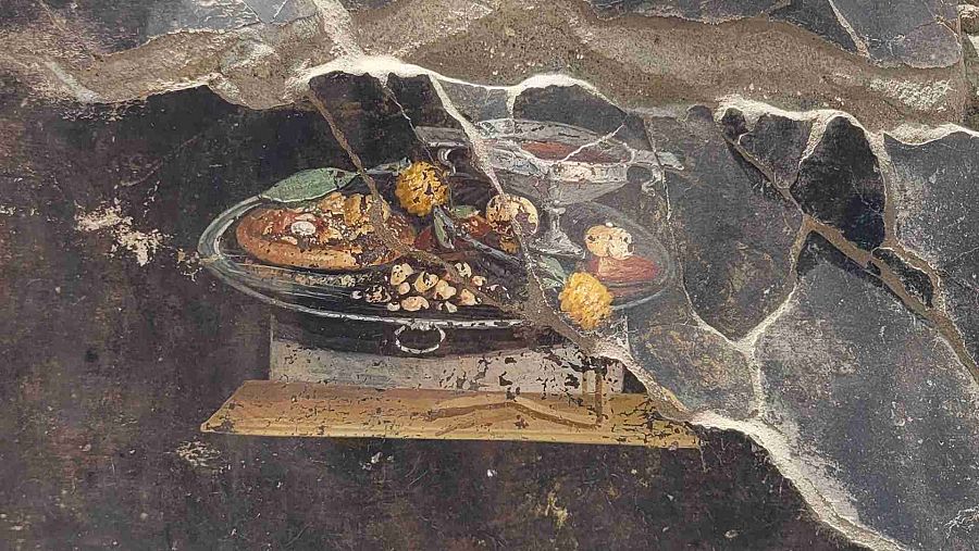 Imagen de lo que podría ser la representación de un plato antepasado de la actual pizza, en un fresco hallado recientemente en las nuevas excavaciones en Pompeya.