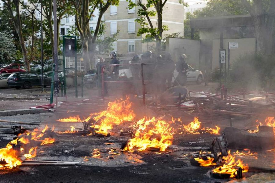 Policías antidisturbios junto a un fuego ardiendo en la calle tras una manifestación en Nanterre, París.