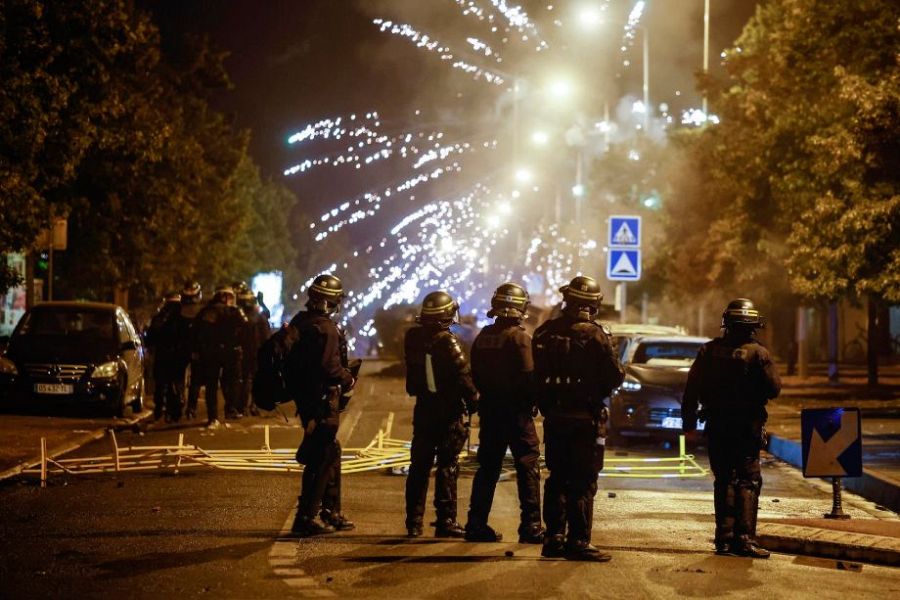 Manifestantes lanzan fuegos artificiales a la policía antidisturbios francesa durante los enfrentamientos en Nanterre, París.