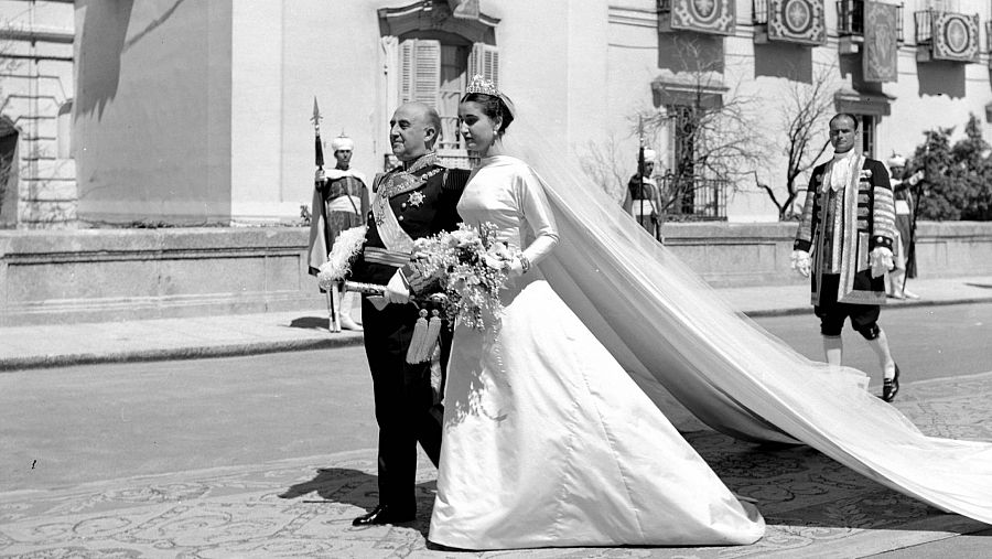 Imagen de Carmen Franco, vestida de novia, del brazo de su padre, Francisco Franco en El Pardo