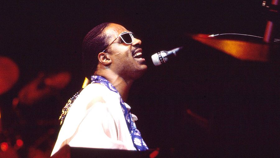 Imagen del artista Stevie Wonder en directo, tocando el piano y cantando al micrófono