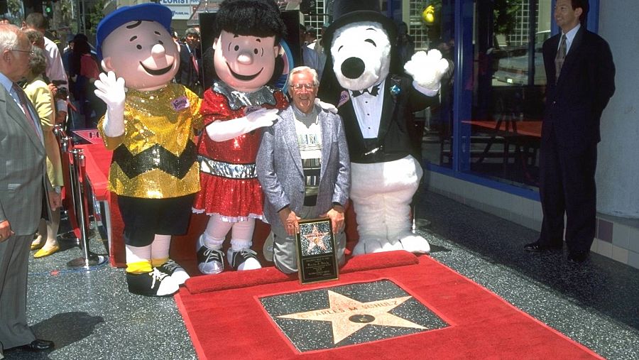 El dibujante Charles Schulz posa junto a muñecos de sus personajes, y junto a su estrella en el Paseo de la Fama de Hollywood