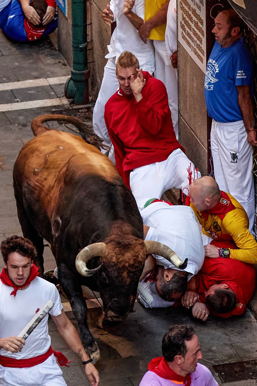 Los mozos, acorralados por un toro en el tramo la curva de Mercaderes al inicio de Estafeta, durante el cuarto encierro de los sanfermines 2023 protagonizado este lunes por la ganadería de Fuente Ymbro