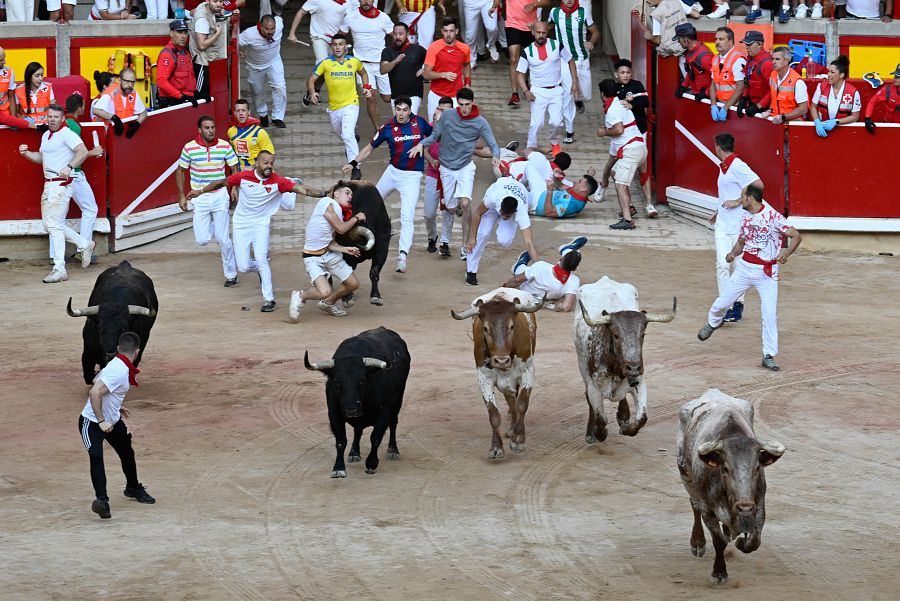 Un mozo es arrollado por uno de los toros de la ganadería de Fuente Ymbro en su entrada a la plaza de toros de Pamplona durante el cuarto encierro de los sanfermines 2023