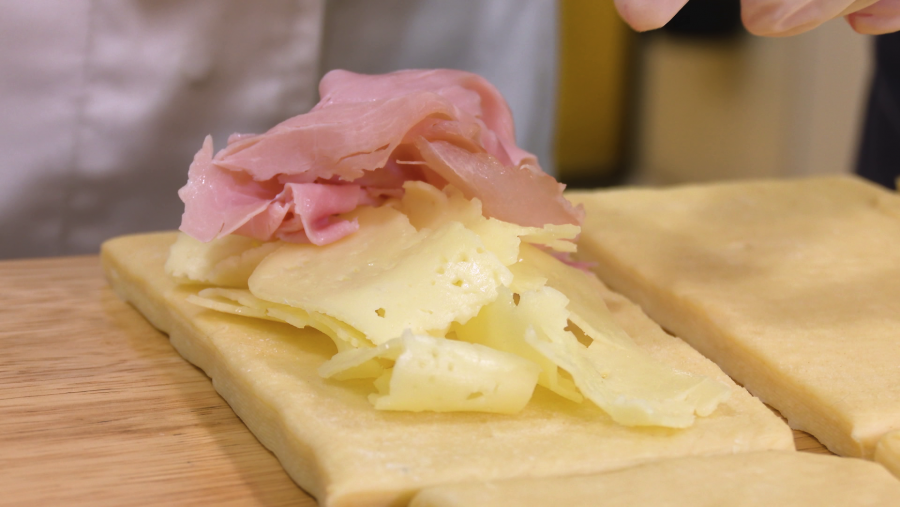 Cortar la masa en rectángulos y rellenarlos con jamón y queso