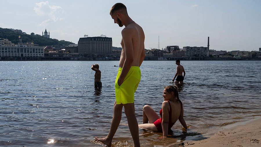 Varias personas se refrescan en el río Dniéper en Kiev, Ucrania