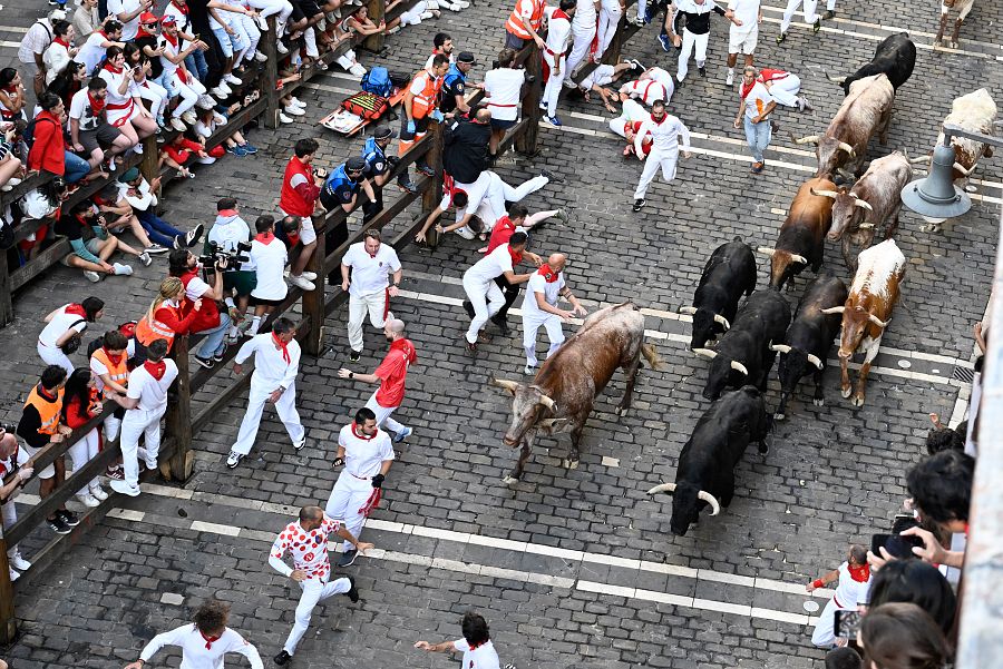 Mozos perseguidos de cerca por toros de la ganadería extremeña Jandilla durante el sexto encierro de Sanfermines