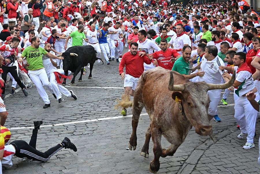 Los mozos se apartan al paso de uno de los toros y un cabestro de la ganadería extremeña Jandilla, durante el sexto encierro de Sanfermines