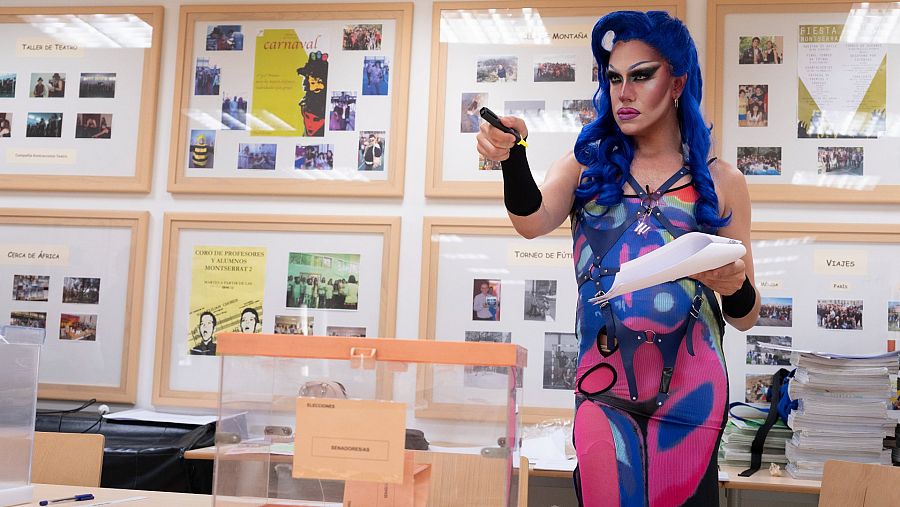 La drag queen Pnyx, ataviada con un vestido de coleres flúor, una peluca azul y maquillaje drag