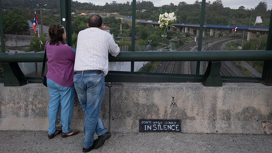 Varias personas en el lugar del descarrilamiento del Alvia durante un homenaje en el barrio de Angrois