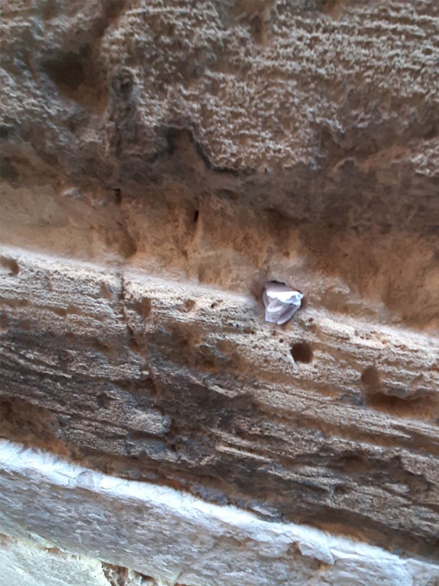 Papeles incrustados en los recovecos del zócalo de Monti-sion, único resto de la gran sinagoga de Palma