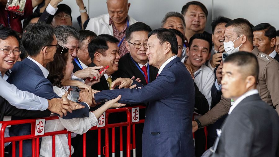 Thaksin Shinawatra saluda a miembros del partido Pheu Thai durante su llegada al aeropuerto de Bangkok.