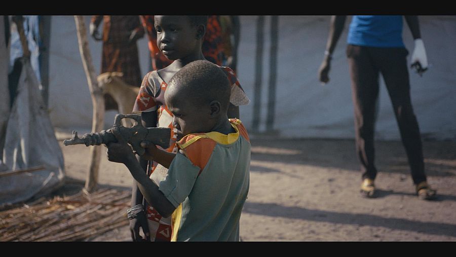 Un niño africano apunta con un rifle