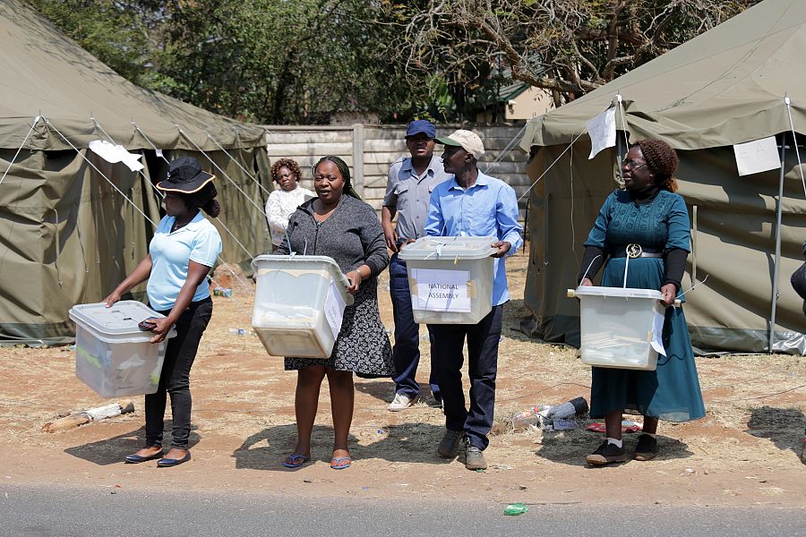 Funcionarios de la Comisión Electoral de Zimbabwe (ZEC) y agentes electorales transportando las urnas.