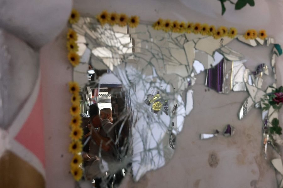 La gente comprueba los daños en una casa después de una incursión militar israelí en Yenín