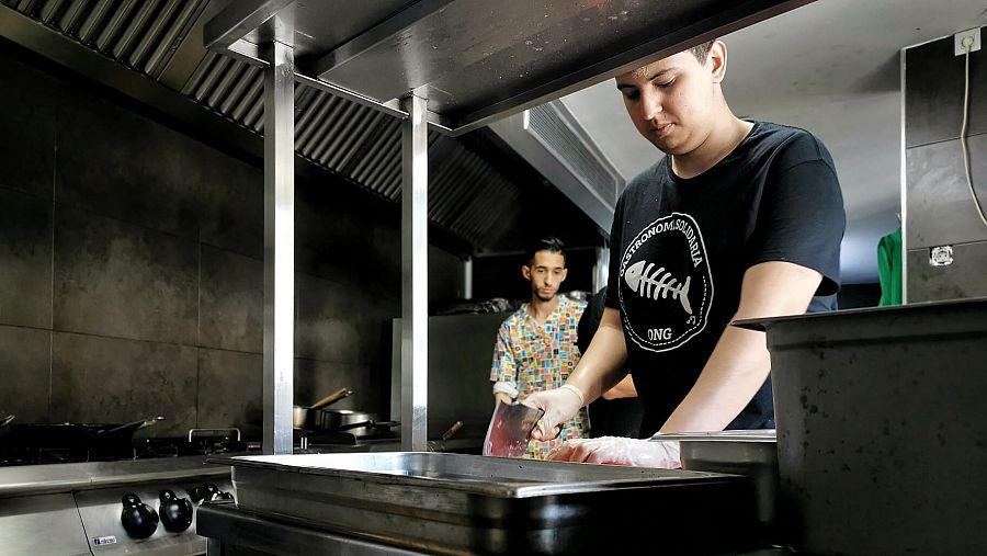 Dos jóvenes con rasgos magrebíes en una cocina industrial