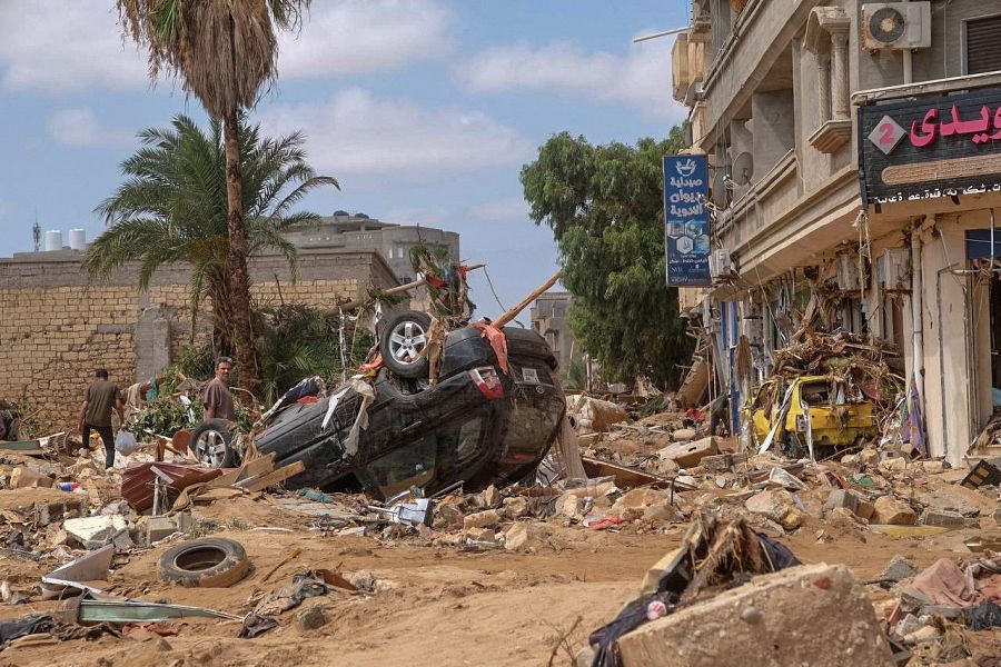 Un hombre junto a un coche dañado en la ciudad de Derna, Libia