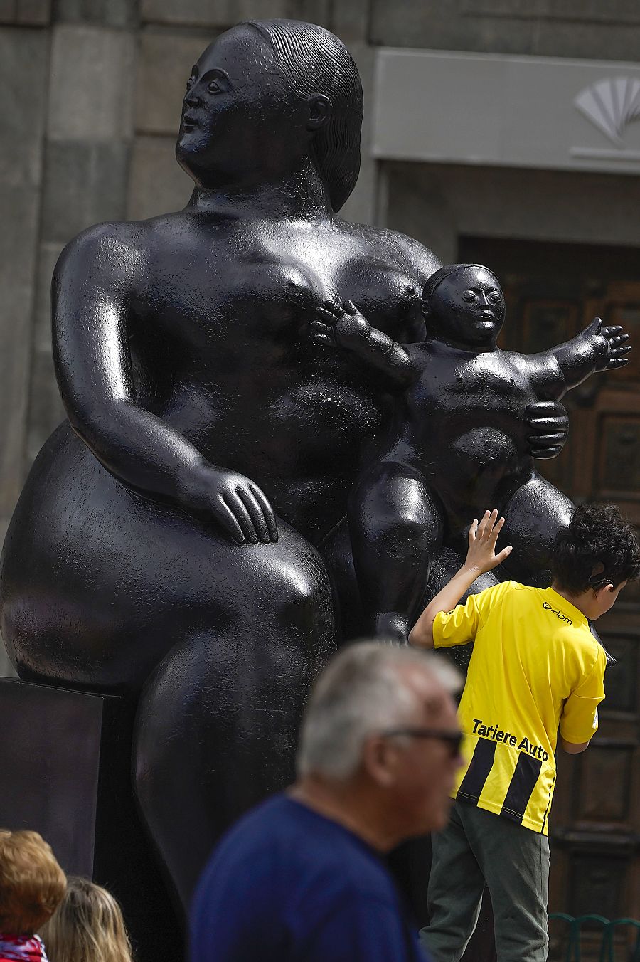 Día de la Un niño subido a la escultura urbana dedicada a 