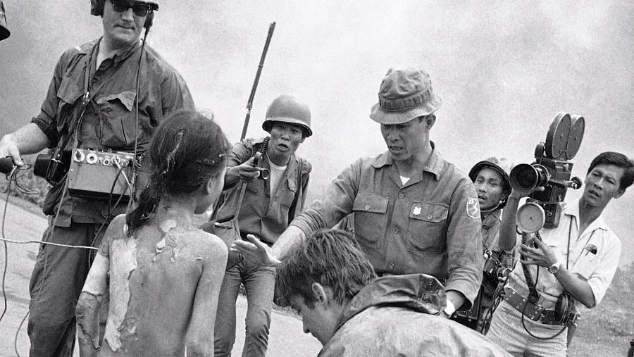 Un soldado ayuda a Kim con la prensa delante