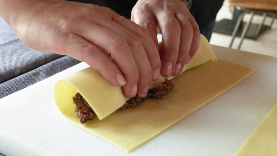 Coger la masa de los canelos e ir rellenando y enrollando uno a uno con la carne.