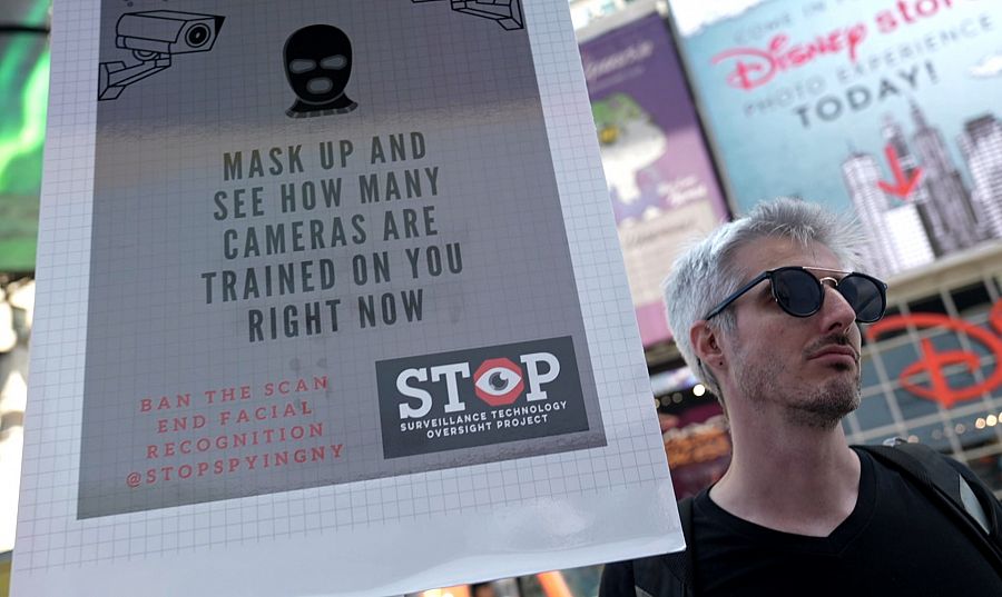Manifestante con pancarta contra el reconocimiento facial