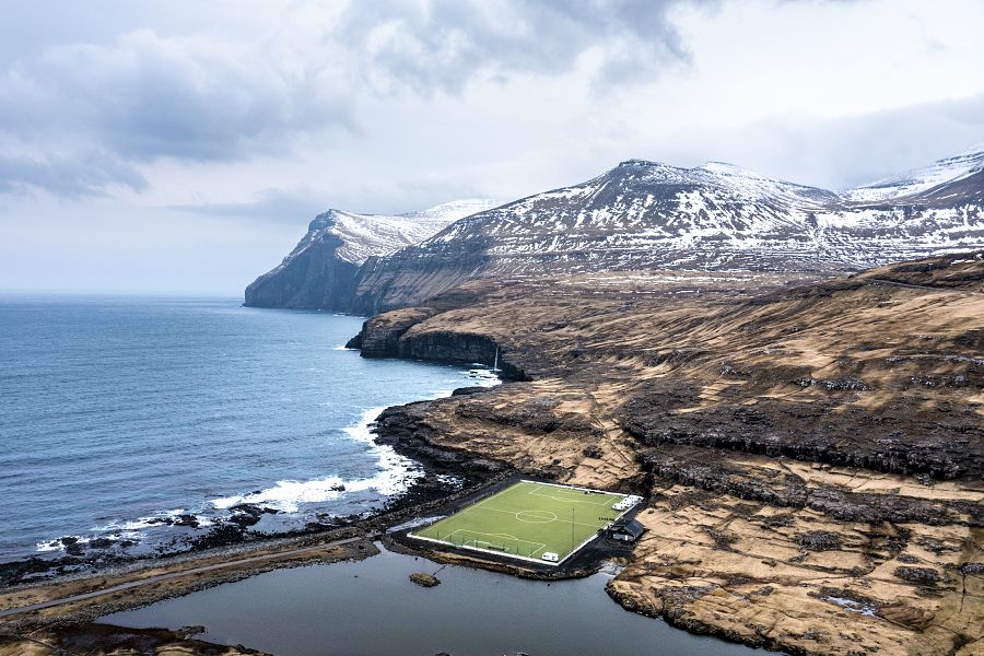 Faroe Islands, Eysturoy, Coastal soccer field and surrounding landscape
