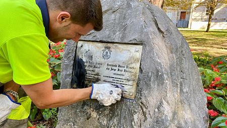 Un operario limpia la placa en recuerdo a Ferrnando Buesa, en Vitoria