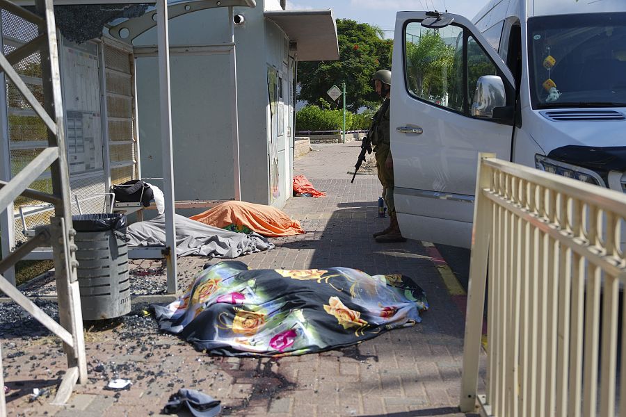 Un soldado israelí junto a los cuerpos de israelíes asesinados por militantes armados palestinos en Sderot