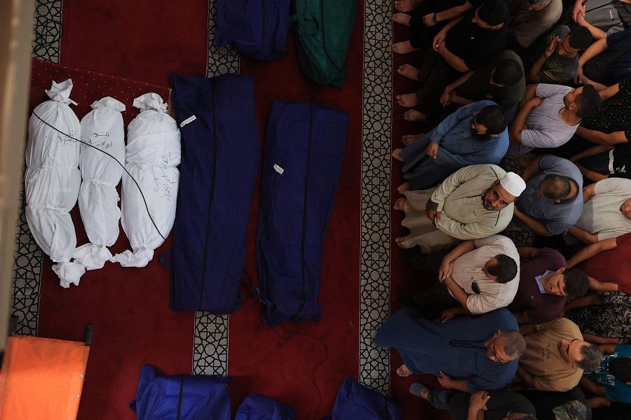 Ciudadanos rezan sobre los cuerpos de sus familiares en Rafah, Franja de Gaza.