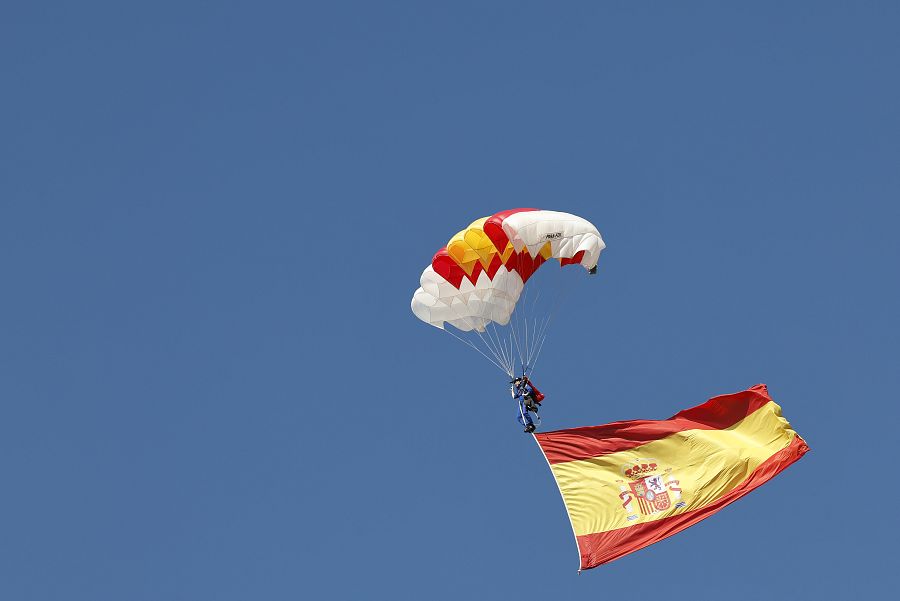 La cabo Mari Carmen Gómez Hurtado desciende la bandera al inicio del desfile