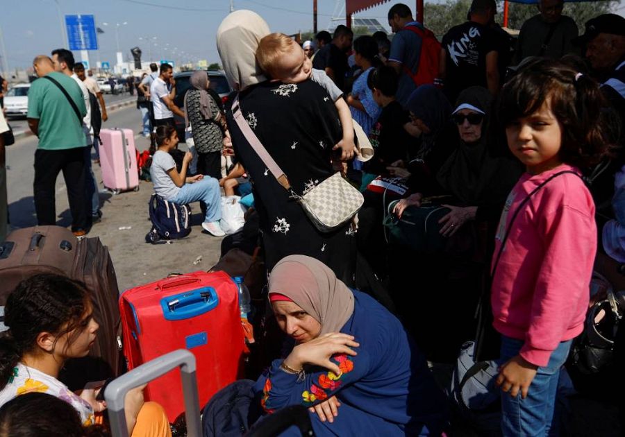 Palestinos con doble nacionalidad esperan junto al cruce de Rafah para abandonar Gaza