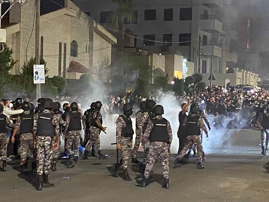 Fuerzas de seguridad jordanas disparan gases lacrimógenos contra manifestantes que intentan asaltar la embajada israelí en la capital, Ammán. 