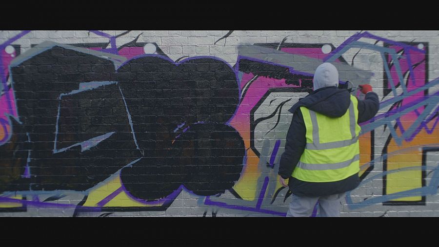Un hombre pinta un grafiti