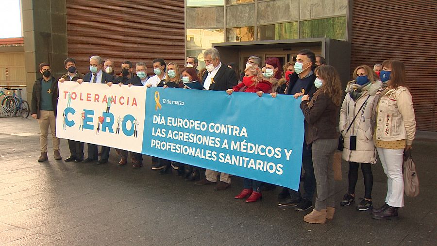 Sanitarios con mascarilla protestan tras una pancarta