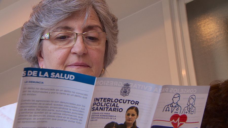 Una mujer lee un folleto informativo sobre agresiones a sanitarios