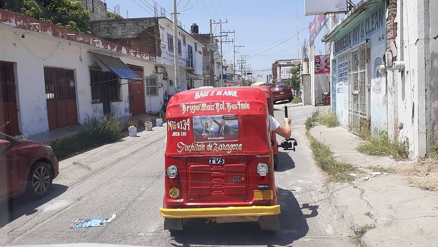 Parte trasera de un mototaxi rojo con letras amarillas en una calle de la ciudad mexicana de Juchitán.