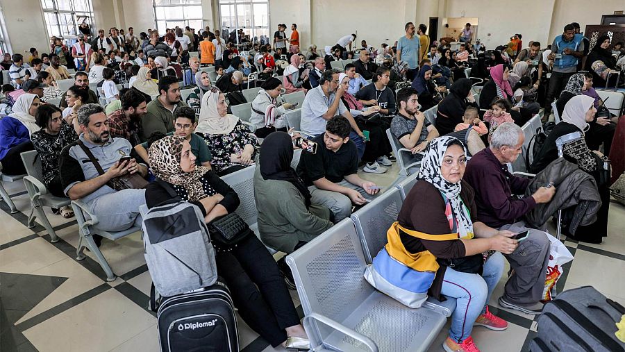Decenas de personas esperan en el cruce fronterizo de Ráfah, antes de cruzar a Egipto