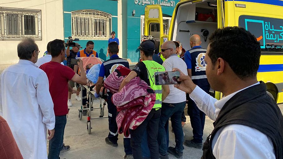 Médicos llevan a un evacuado herido a un hospital tras pasar el paso fronterizo
