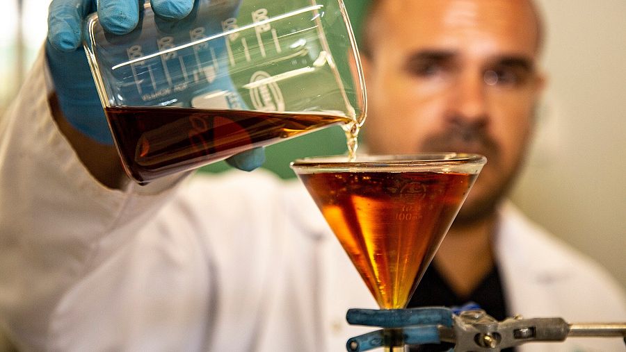 Químico mezcla sustancias en laboratorio