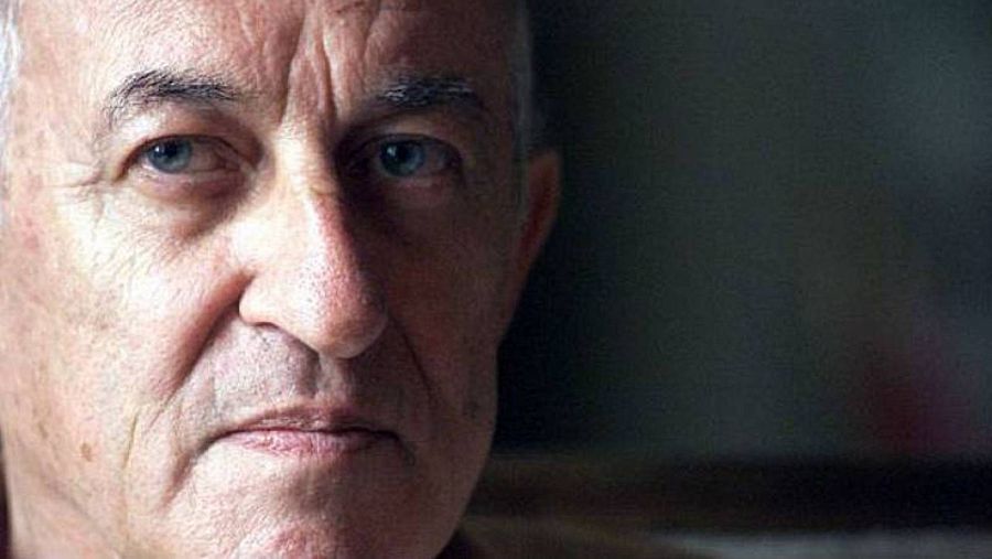 Primer plano del rostro de Juan Goytisolo, al lado izquierdo de la foto. al lado derecho, el fondo se aprecia más oscuro y desenfocado.