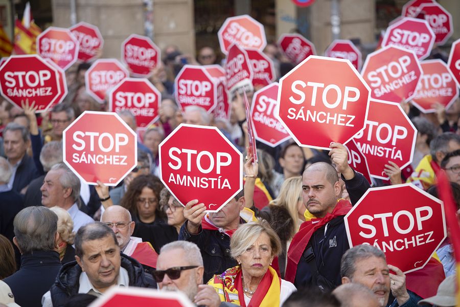 Manifestantes sostienen carteles con la frase 