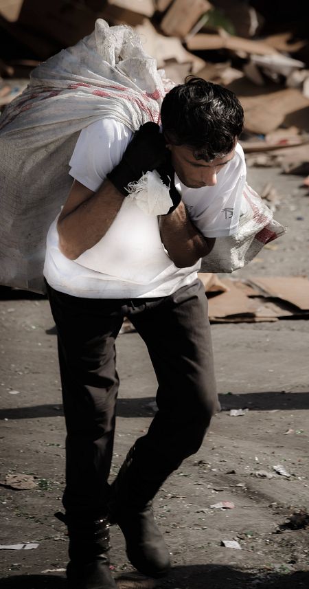 Hombre carga un saco de basura con plástico