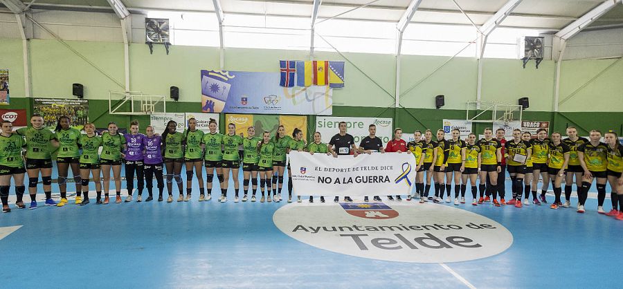 Jugadoras del Rocasa y del HC Galychanka, con una pancarta contra la guerra antes del partido de Copa EHF disputado en Telde en 2022