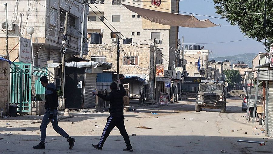 Jóvenes palestinos ante los soldados israelíes en el campo de refugiados en Yenín, Cisjordania.