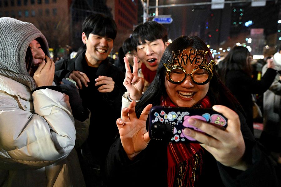 Un grupo de personas celebra la llegada del Año Nuevo en el pabellón Bosingak, en el centro de Seúl, después de la medianoche del 1 de enero de 2024.